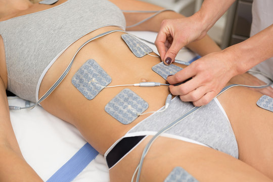 Therapist applying lipomassage on girls body in spa. Close-up of biostimulating apparatus for anti-cellulite lipomassage. Hardware cosmetology. Body care