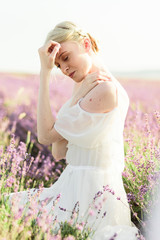 Wonderful portrait of girl in light dress in lavender field on sunset