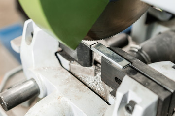 Circular saw machine. Cutting a metal and steel with with sharp, circular blade in workshop interior. Tool store or exposition stand.