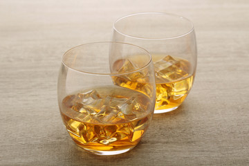 Two glasses with whiskey with ice cubes	