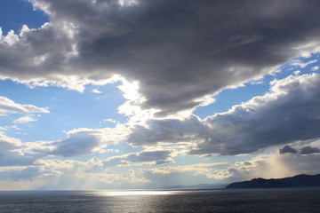 Obraz premium Beautiful sunset on the sea. The sun is shining from behind the clouds.