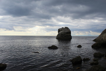 Fototapeta na wymiar Rock like a skull. A mountain of water resembling a dead head in the sea.