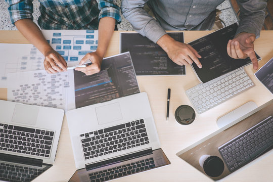 Professional Developer programmer cooperation meeting and brainstorming and programming in website working a software outsourcing and coding technology, writing codes and database