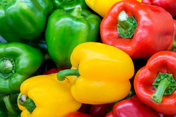 Red and yellow and Green sweet peppers. Pile Three sweet peppers on a wooden background, Cooking vegetable salad . Colorful sweet bell peppers, natural background.