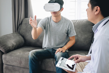 Young asian man patient using virtual reality glasses to see technology