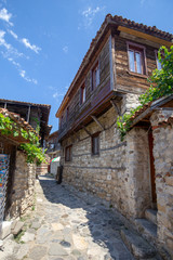 Fototapeta na wymiar NESSEBAR, BULGARIA, August 9, 2018 - View of a narrow street with traditional Bulgarian wooden houses in old Nessebar