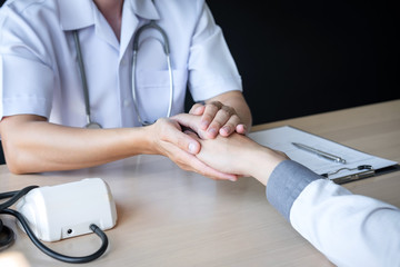 Image of doctor holding patient's hand to encourage, talking with patient cheering and support