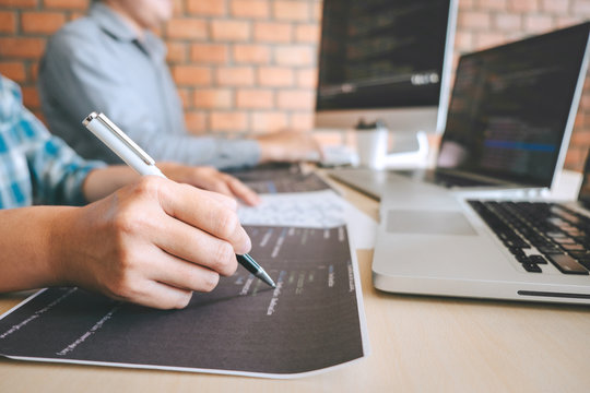 Professional Developer programmer cooperation meeting and brainstorming and programming in website working a software outsourcing and coding technology, writing codes and database