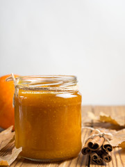 pumpkin jam on a wooden table with dry autumn leaves. thanksgiving day