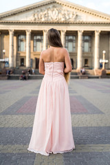 Urban portrait of young, slim, beautiful model in pink dress