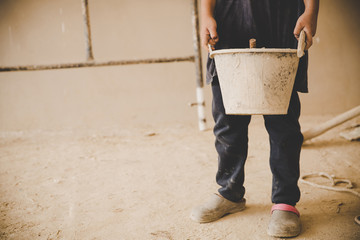 Little Child labor working in commercial building structure, World Day Against Child Labour concept.