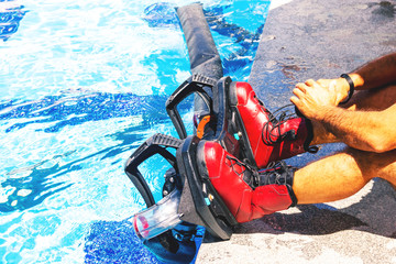 ..Man tying shoelaces of fly board boots, man on a Flyboard in red