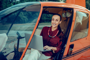 Naklejka premium Long-haired appealing female with wide smile carrying laptop