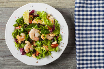 Shrimp salad with tomato, olives and cashew nuts.