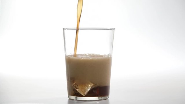 Refresco de cola cayendo en vaso sobre fondo blanco 4k