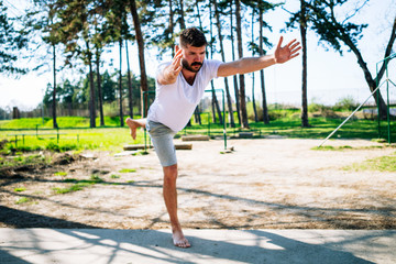 Young man doing yoga pose in the park