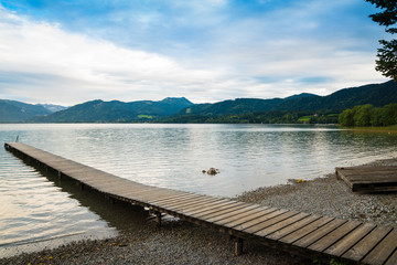 Obraz premium Picturesque view of wooden pier in the beach of Tegernsee lake near Gmund am Tegernsee in Germany