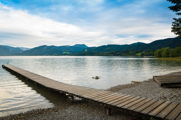 Picturesque view of wooden pier in the beach of Tegernsee lake near Gmund am Tegernsee in Germany