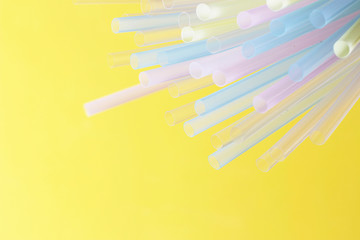 Multicolored straw on a yellow background close-up, party concept