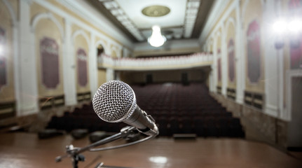 Microphone over the Abstract blurred photo of conference hall or seminar room background