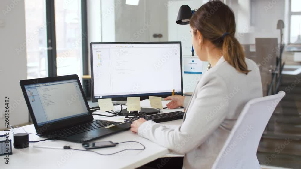 Poster business, programming and technology concept - female programmer with notebook, sticky notes and com