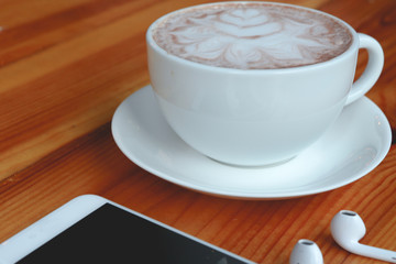 Cup of coffee with smartphone and earphone. 