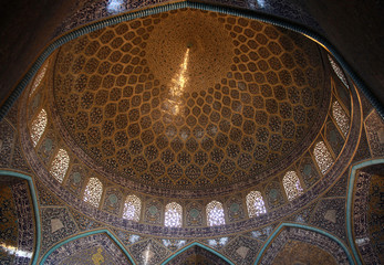 snop światła wpadający do wnętrza kopuły zabytkowego irańskiego meczetu - obrazy, fototapety, plakaty