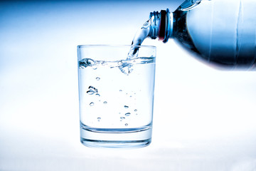 pouring water on a glass on white background