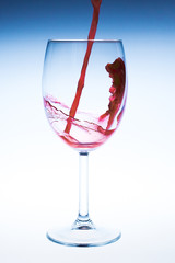 Splash red wine glass against a white background