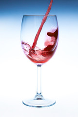 Splash red wine glass against a white background
