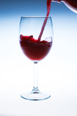 Splash red wine glass against a white background
