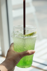 hand holding Iced kiwi soda.
