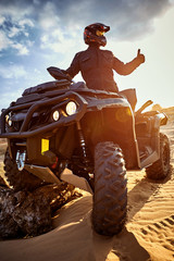 Racing in the sand on a four-wheel drive quad. © Bondariev Volodymyr.
