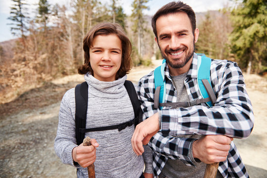 Portrait of dad and his son with backpacks in the forest