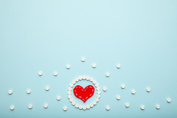 Aspirin tablets and red heart. Cardiology and medicine, healthcare and pharmacy concept.