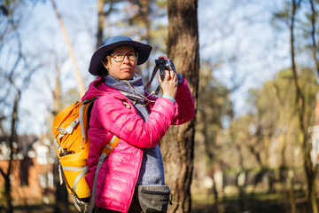 tourist woman in the forest with photo camera