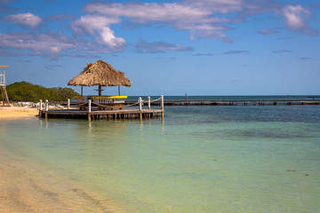 Palapas on the Beach in Belize island. Small tropical island at Barrier Reef with paradise beach, known for diving, snorkeling and relaxing in the beach. Caribbean Sea, Belize, Central America.