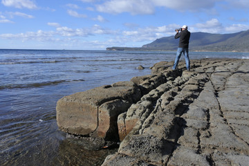 Travel photographer photographing Tessellated Pavement in Tasman Peninsula Tasmania Australia