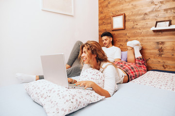 Young smiling heterosexual couple lying down together on the bed