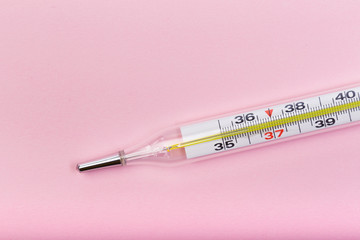 medical  thermometer  on pink   background close up view