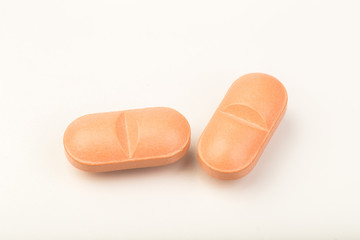 pink  pills close up on white background
