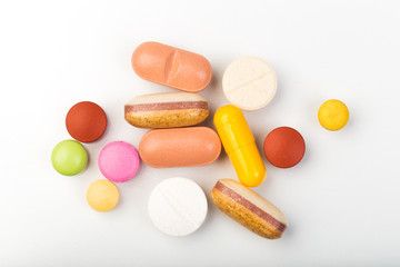 set of multi-colored tablets and capsules on a white background