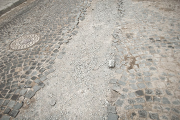 Paving the street in the city. Replacement of old paving tiles. Repairs. The pits on the roads, the old damaged cobblestone. Chernivtsi, Ukraine, Europe, March 2019.