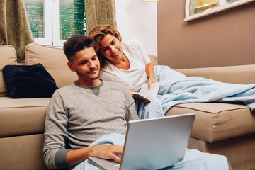 Young smiling heterosexual couple together on sofa