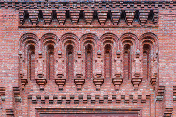 Fragment of an old red brick building facade. Beautiful ornamental brickwork.
