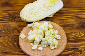 Chopped chinese cabbage on cutting board on wooden table