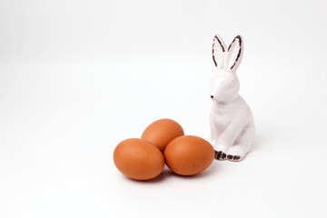Fototapeta na wymiar easter bunny ceramic figurine three eggs on white background