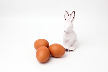 Naklejka na ściany i meble easter bunny ceramic figurine three eggs on white background