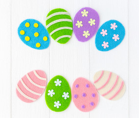 Closeup top view photo of cute diy colorful pastel eggs decorated with dots, stripes and flowers isolated on white painted wooden background. Happy Easter holiday greeting cards. Horizontal image.
