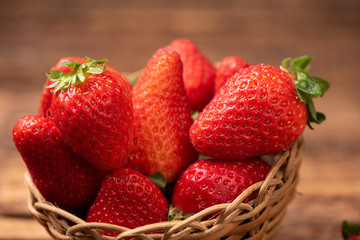 Strawberries in a basket on old wooden table
